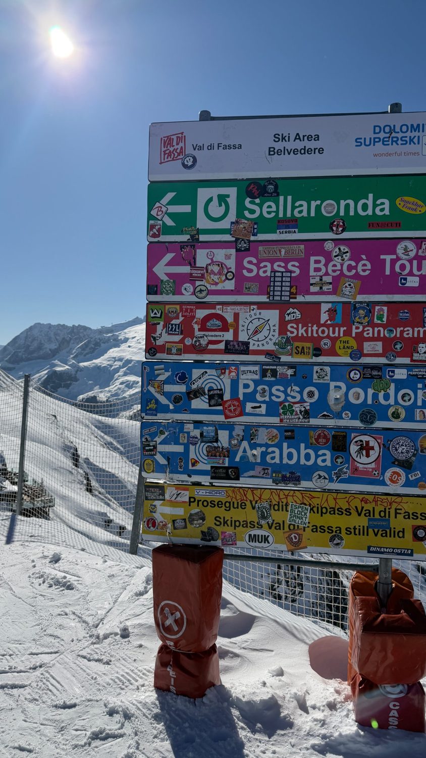 Wegweiser mit Aufklebern am Belvedere, Dolomiten: Sellaronda, Passo Pordoi, Arabba